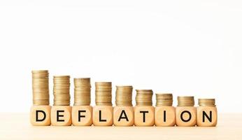 Deflationskonzept. Text auf Holzklötzen und gestapelten Münzen. Platz kopieren foto