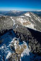 luftaufnahme über berg mit schneebedeckten kiefern in bayern bei garmisch partenkirchen foto