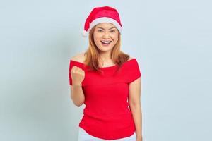 fröhliche junge asiatische frau, die weihnachtskleid trägt, aufgeregt, weihnachten auf weißem hintergrund zu feiern foto