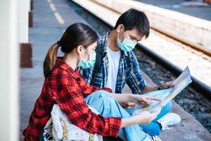 männliche und weibliche Touristen schauen sich die Karte neben der Bahn an. foto