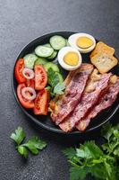englisches Frühstück Speck, Ei, Tomate, Gurke, Toastbrot foto