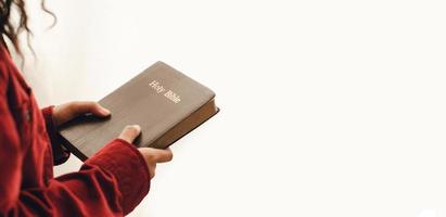 eine junge frau, die auf der bibel steht und betet, kopierraum. neben dem Spiegelfenster foto