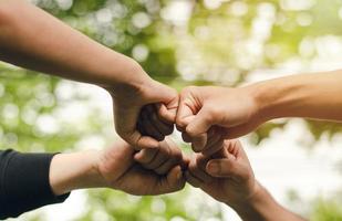 4 Personen schließen sich zusammen, das Konzept der Hand-zu-Hand, um Einheit, Gruppe von Menschen, Hände, Teamwork-Geschäftsgruppe zu schaffen, indem sie sich in einem Kreis ausstrecken. Die Kraft der Arbeit ist die Freundschaft mit Geschäftskollegen. foto