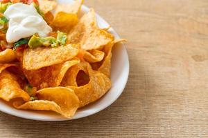 Nachos-Tortilla-Chips mit Jalapeno, Guacamole, Tomatensalsa und Dip foto