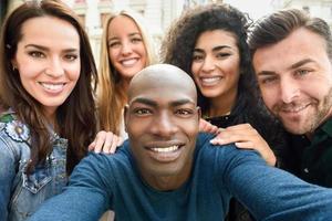gemischtrassige Gruppe junger Leute, die Selfies machen foto