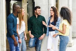 multiethnische Gruppe von Freunden, die zusammen im städtischen Hintergrund Spaß haben foto