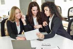 Drei Geschäftsfrauen arbeiten in einem modernen Büro zusammen foto