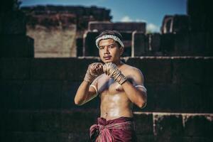 ein boxer band sich ein seil in die hand und führte einen kampf aus, die kampfkunst des muay thai. foto