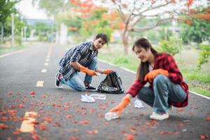 Männer und Frauen helfen sich gegenseitig beim Müllsammeln. foto