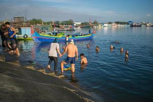 Mayangan-Probolinggo. März 2020 baden Menschen am Strand, von dem sie glauben, dass er viele Krankheiten heilen kann foto