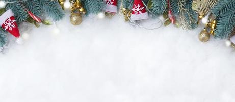 Banner mit Tannenzweigen und Weihnachtsschmuck flach auf schneebedecktem Hintergrund mit Kopierraum foto