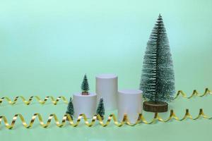 Modelle von Podesten für Kosmetik mit Weihnachtsbäumen auf Weihnachtshintergrund mit goldenen Bändern. Nahansicht foto