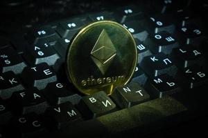 Goldmünze Ethereum Eth auf Tastatur Nahaufnahme Kryptowährung Einkaufen und Geld verdienen online foto