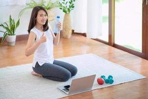 schöne asiatische frau, die fit bleibt, indem sie zu hause für einen gesunden trend-lebensstil trainiert