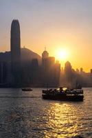 Hongkong traditionelles chinesisches Holzboot für Touristenservice im Hafen von Victoria bei Sonnenuntergang von der Kowloon-Seite in Hongkong