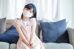 Asiatisches süßes Mädchen mit hygienischer Gesichtsmaske zur Vorbeugung von Coronavirus oder Covid-19