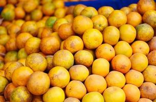 Haufen von Orangenfrüchten zum Verkauf auf dem Markt - frischer orangefarbener Hintergrund foto