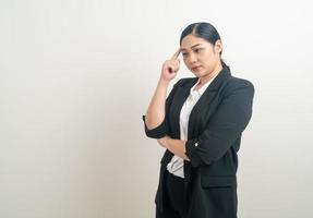 asiatische Frau, die mit weißem Hintergrund denkt foto