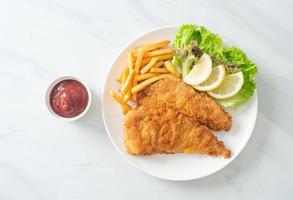 hausgemachtes paniertes Weinerschnitzel mit Kartoffelchips foto