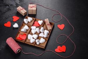 schöner Hintergrund mit weißen und roten Herzen auf einem dunklen Tisch foto