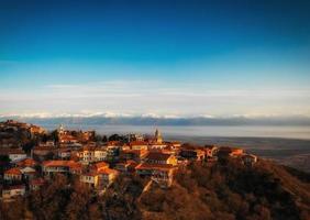 Luftpanoramablick auf die Liebesstadt Sighnaghi mit dem Hintergrund der Kaukasusberge. Leerraum-Touristenattraktionsbanner foto