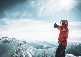 männliche person aloen im winterskioutfit aufgeregt genießt das panorama der berge mit ausgebreiteten händen. Gudauri-Skifahren in Georgien. foto