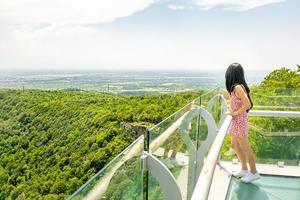 Attraktive weibliche Person steht auf Sataplia-Aussichtspunkt-Anzeige genießt ein atemberaubendes grünes Waldpanorama. foto