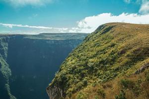 felsiger Weg, der an einem sonnigen Tag in der Nähe von Cambara do Sul durch trockene Büsche zu einer Klippe auf der Fortaleza-Schlucht führt. eine kleine landstadt im süden brasiliens mit erstaunlichen natürlichen touristenattraktionen. foto