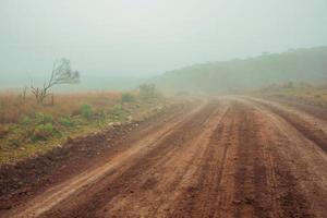 Landschaft mit langer Schotterstraße und niemandem in der Nähe, an einem nebligen Tag in der Nähe von Cambara do Sul. eine kleine ländliche stadt im süden brasiliens mit erstaunlichen natürlichen touristenattraktionen. foto