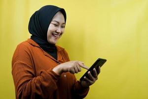 Schöne junge asiatische muslimische Frau mit Smartphone, selbstbewusst lächelnd, isoliert, Werbekonzept foto