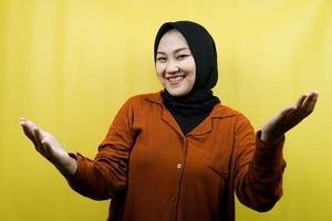 schöne junge asiatische muslimische frau mit offenen armen zur kamera, willkommensschild hand, handzeichen, die sich umarmen möchte, fröhlich lächelnd, isoliert foto