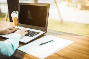 Nahaufnahme der Geschäftsfrau, die mit Laptopkaffee im Café arbeitet, wie der Hintergrund. foto