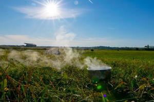 Campingkocher und Dampf kommen an einem sonnigen Frühlingstag mit blauem Himmel während des Campingabenteuers aus der Schüssel. litauen landschaft. foto