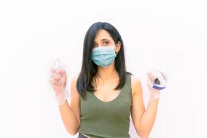 Person mit Desinfektionsflüssigkeit und Gesichtsschutz foto