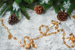 Neujahrs- oder Weihnachtskomposition aus fichtengrünen Zweigen, Tannenzapfen und Neujahrs- und glänzenden goldenen Spielzeugen foto