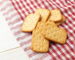 Cracker Cookies mit Tischdecke auf weißem Holztisch Hintergrund