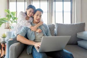 asiatische Paarliebhaber genießen es, Online-Streaming über Computer-Laptop zu Hause zu sehen