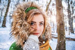 schönes junges Mädchen in einem Winterwald. Winterporträt von Frauen in Fäustlingen und Schal foto