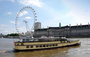 London, Großbritannien, 2014 - Bewegung von Booten auf der Themse. das London Eye im Hintergrund. London