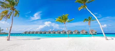 tolles Panorama auf den Malediven. Luxus-Resort-Villen mit Palmen, weißem Sand und blauem Himmel. schöne Sommerlandschaft. erstaunlicher strandhintergrund für urlaubsferien. Konzept der Paradiesinsel foto