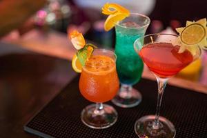 Verschiedene leckere Cocktails auf schwarzem Tisch in der Bar. Party, Nachtclub buntes Bannerkonzept