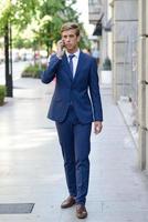 attraktiver junger Geschäftsmann am Telefon im städtischen Hintergrund foto