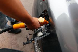 Hand-Mann-Nachfüllen und Füllen von Öl-Gas-Kraftstoff an der Station. foto