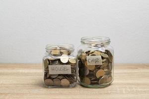 Münze in einem Glas, um Geld auf dem braunen Tisch zu sparen und Platz zu kopieren foto