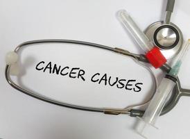 Krebs verursacht Wort, medizinisches Begriffswort mit medizinischen Konzepten in Whiteboard und medizinischen Geräten foto
