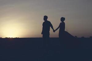 Silhouette eines romantischen jungen Paares am Strand foto