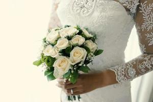 Hochzeitsblumenstrauß in den Händen der Braut foto