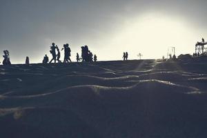 Silhouetten von Menschen, die morgens am Strand spielen foto