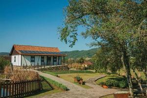 Nova Petropolis, Brasilien - 20. Juli 2019. Haus im deutsch beeinflussten Stil mit Garten inmitten ländlicher Landschaft im Skulpturenpark Steine der Stille in der Nähe von Nova Petropolis. foto