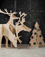 Neujahrs- und Weihnachtsschmuck und Tannensperrholz Hirsche und ein Baum auf dunklem Hintergrund foto